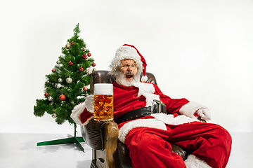 Image showing Santa Claus drinking beer near Christmas tree, congratulating of