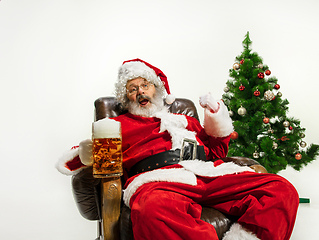Image showing Santa Claus drinking beer near Christmas tree, congratulating of