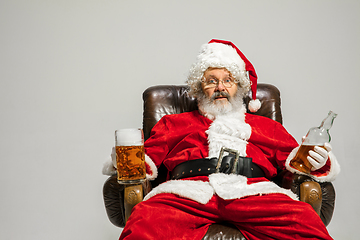 Image showing Santa Claus drinking beer sitting on armchair, congratulating of New Year 2020