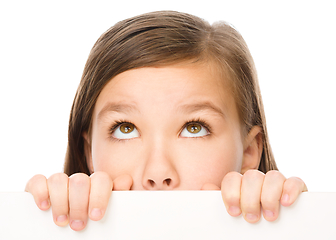 Image showing Little girl is looking from out blank board