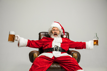 Image showing Santa Claus drinking beer sitting on armchair, congratulating of New Year 2020