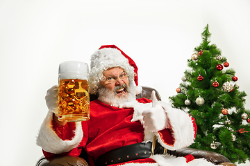 Image showing Santa Claus drinking beer near Christmas tree, congratulating of