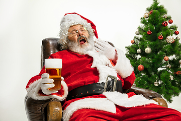 Image showing Santa Claus drinking beer near Christmas tree, congratulating of