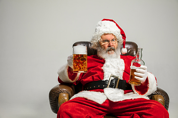 Image showing Santa Claus drinking beer sitting on armchair, congratulating of New Year 2020