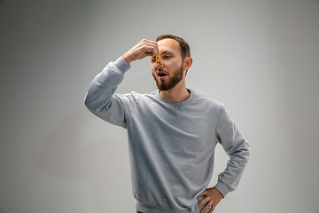 Image showing Caucasian man wearing the respiratory protection pin clasp against air pollution and dusk on grey studio background