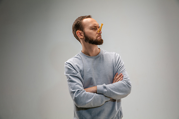 Image showing Caucasian man wearing the respiratory protection pin clasp against air pollution and dusk on grey studio background