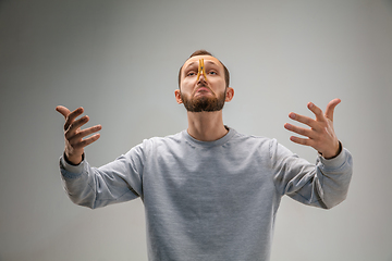 Image showing Caucasian man wearing the respiratory protection pin clasp against air pollution and dusk on grey studio background