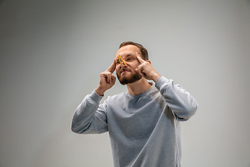 Image showing Caucasian man wearing the respiratory protection pin clasp against air pollution and dusk on grey studio background