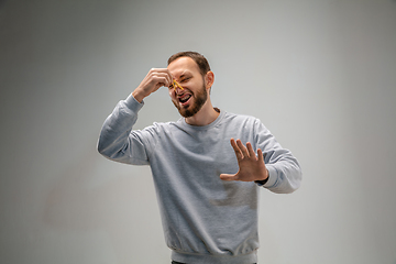 Image showing Caucasian man wearing the respiratory protection pin clasp against air pollution and dusk on grey studio background