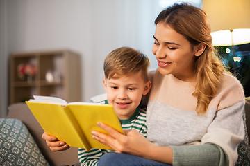 Image showing happy mother and son reading book sofa at home