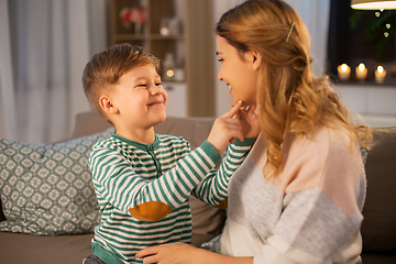 Image showing happy smiling mother talking to her son at home