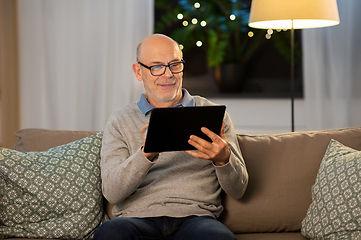 Image showing happy senior man with tablet computer at home