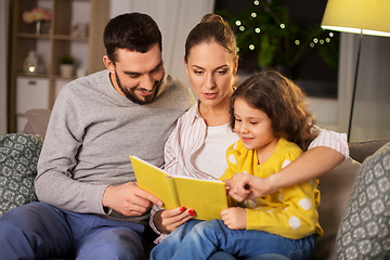 Image showing happy family reading book at home at night