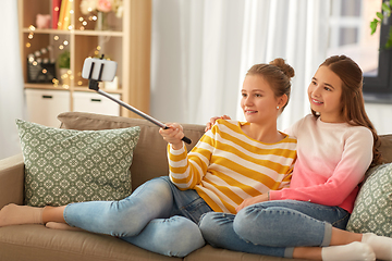 Image showing happy girls taking selfie with smartphone at home