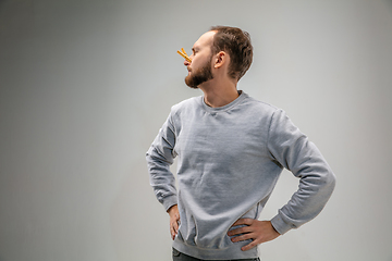 Image showing Caucasian man wearing the respiratory protection pin clasp against air pollution and dusk on grey studio background