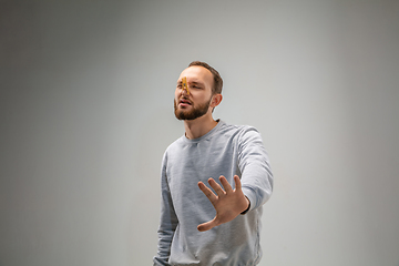 Image showing Caucasian man wearing the respiratory protection pin clasp against air pollution and dusk on grey studio background