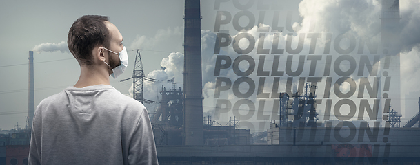 Image showing Caucasian man wearing the respiratory protection mask against air pollution and dusk with factories on background