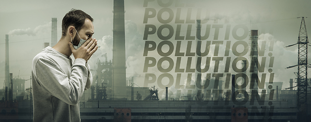 Image showing Caucasian man wearing the respiratory protection mask against air pollution and dusk with factories on background