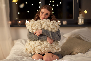 Image showing happy young woman with soft pillow in bed at home