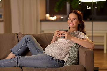 Image showing smiling pregnant woman drinking tea at home