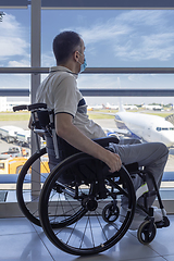 Image showing Young man with protective mask in a wheelchair at the airport 