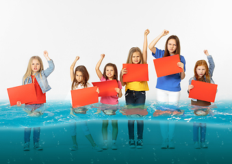 Image showing Group of children with blank red banners standing in water of melting glacier, global warming