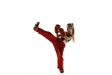 Image showing Young female kickboxing fighter training isolated on white background