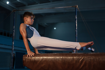 Image showing Little male gymnast training in gym, flexible and active
