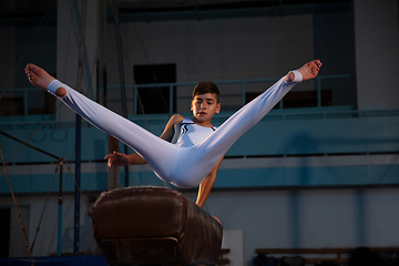 Image showing Little male gymnast training in gym, flexible and active