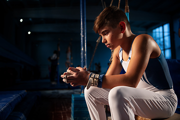 Image showing Little male gymnast training in gym, flexible and active