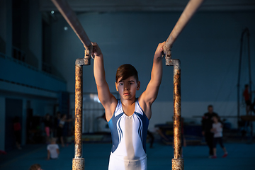 Image showing Little male gymnast training in gym, flexible and active