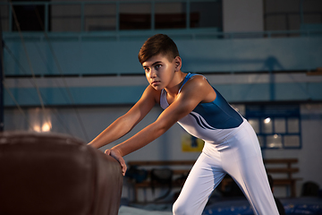 Image showing Little male gymnast training in gym, flexible and active