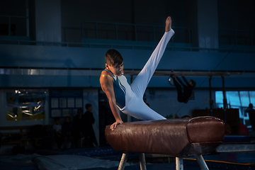 Image showing Little male gymnast training in gym, flexible and active