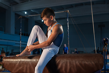 Image showing Little male gymnast training in gym, flexible and active