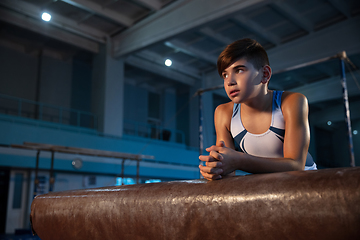 Image showing Little male gymnast training in gym, flexible and active