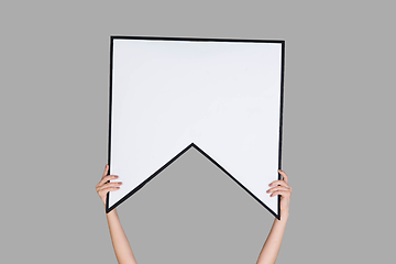 Image showing Hands holding the sign of bookmark on grey studio background