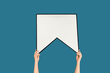 Image showing Hands holding the sign of bookmark on blue studio background