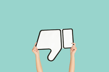 Image showing Hands holding the sign of dislike on blue studio background