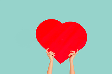 Image showing Hands holding the sign of heart on blue studio background