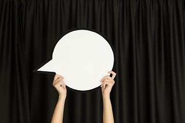 Image showing Hands holding the sign of comment on black studio background