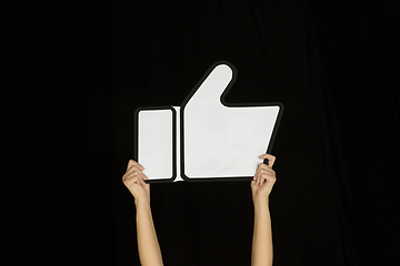 Image showing Hands holding the sign of like on black studio background