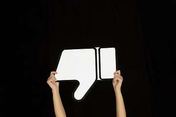 Image showing Hands holding the sign of dislike on black studio background