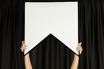 Image showing Hands holding the sign of bookmark on black studio background