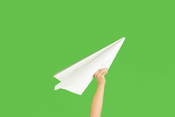 Image showing Hands holding the sign of paper airplane on green studio background