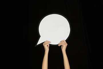 Image showing Hands holding the sign of comment on black studio background