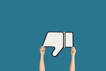 Image showing Hands holding the sign of dislike on blue studio background