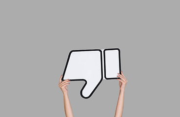 Image showing Hands holding the sign of dislike on grey studio background