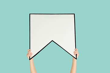 Image showing Hands holding the sign of bookmark on blue studio background