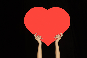 Image showing Hands holding the sign of heart on black studio background