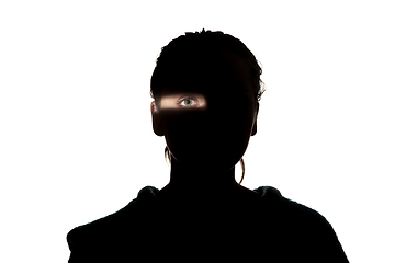 Image showing Dramatic portrait of a girl in the dark on white studio background.